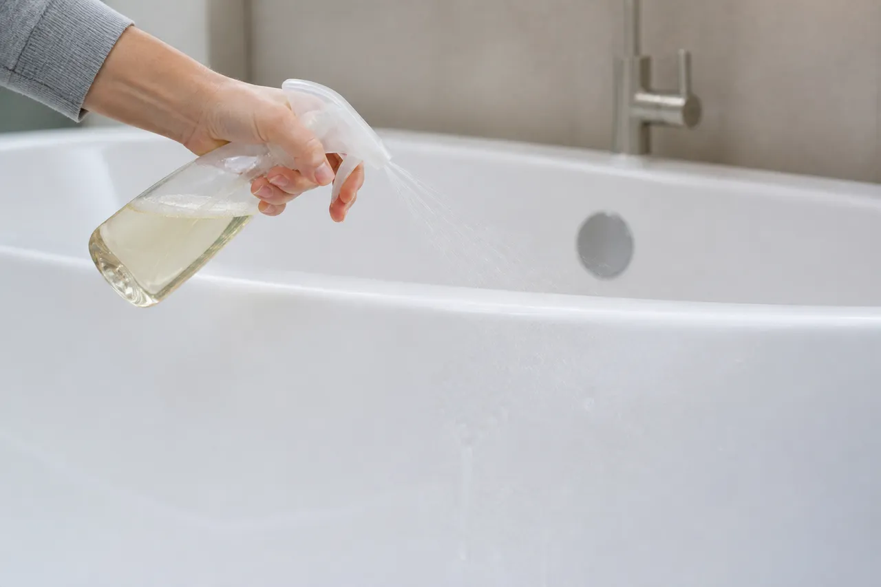 Nettoyer une baignoire avec un spray et une éponge douce